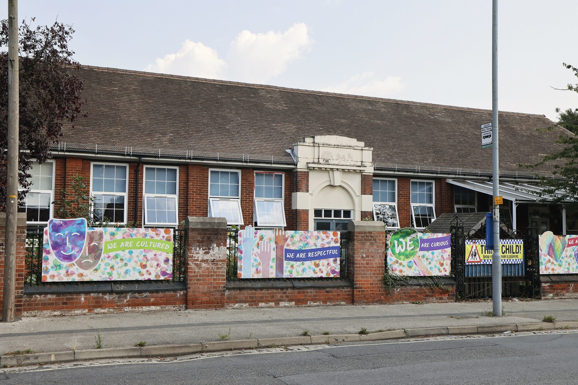The frontage of the school with colourful banners hanging from the railings